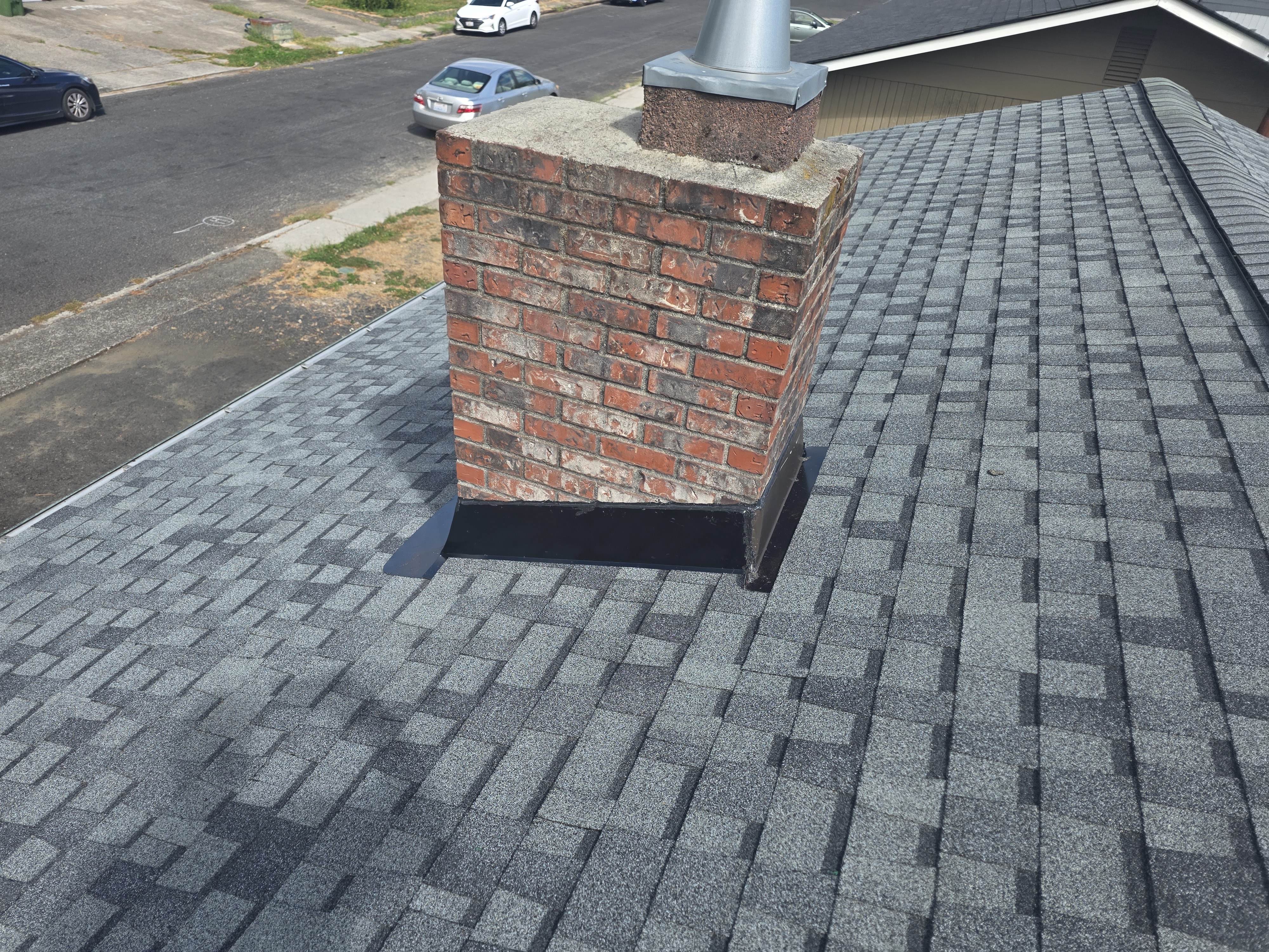 New architectural shingles and chimney flashing after TK Construction reroofed the house