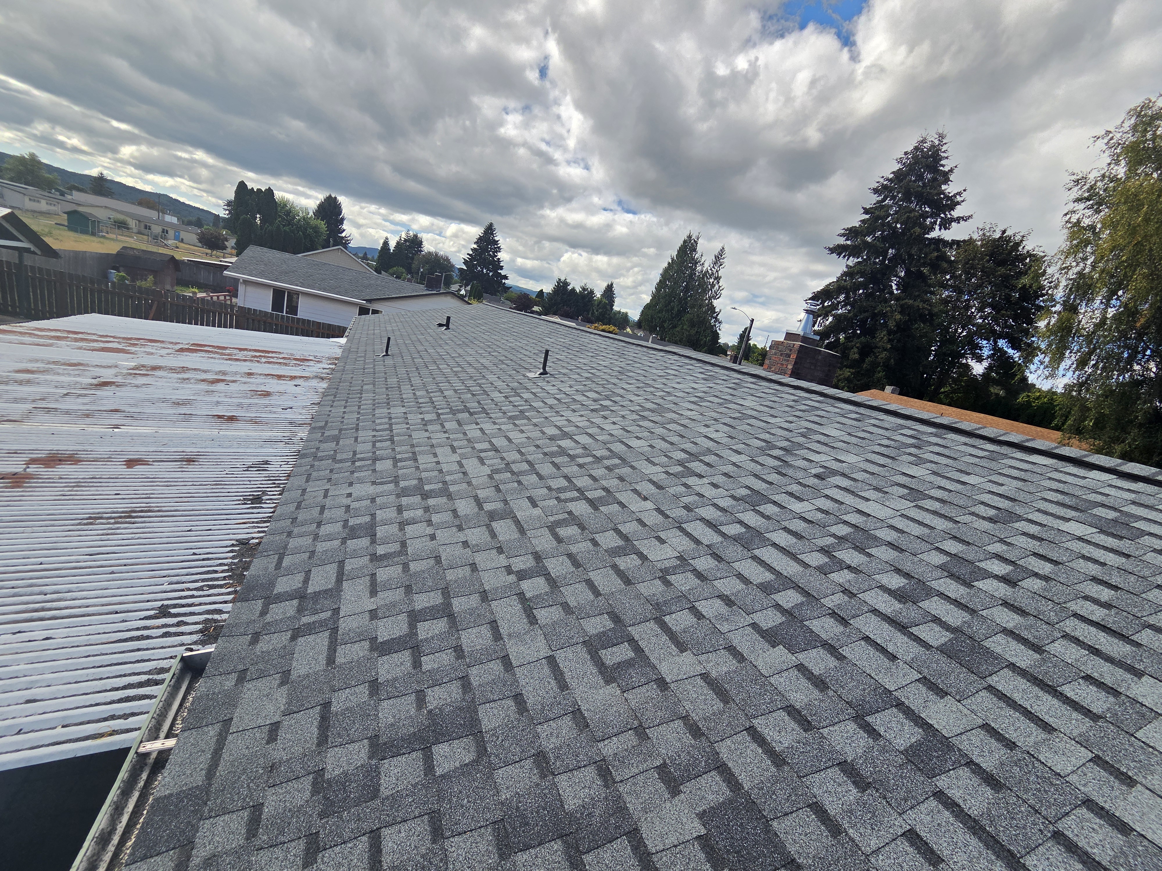 Newly installed gray architectural shingles across a residential roof