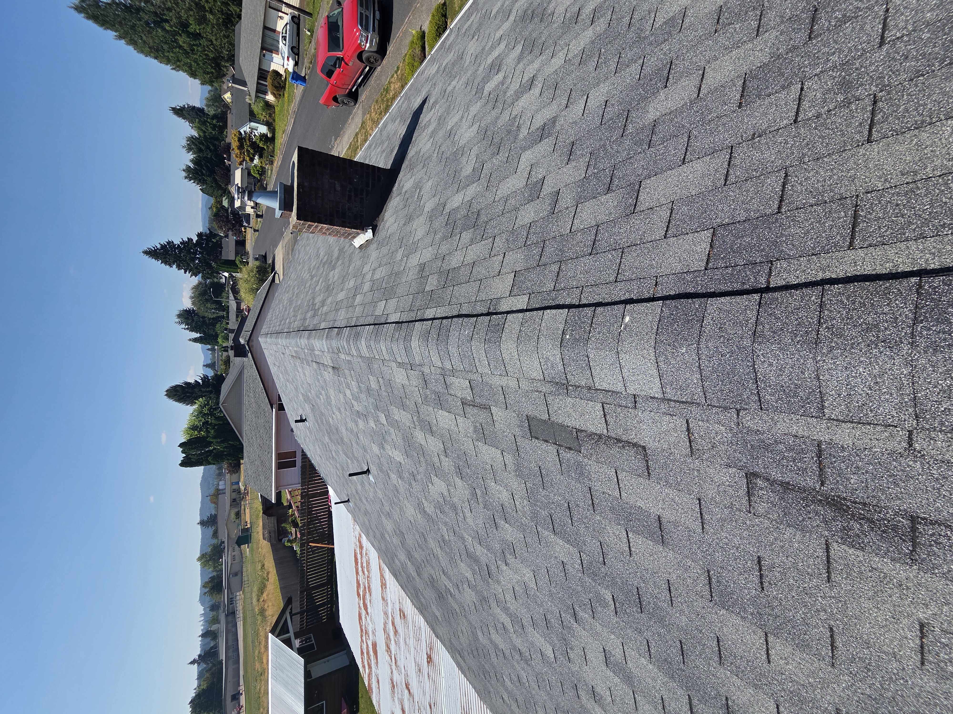 Aged and stained asphalt shingles along the ridge before replacement
