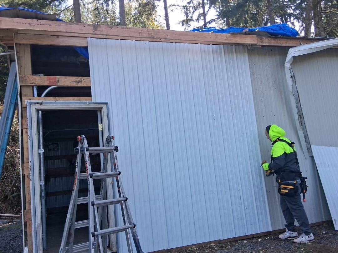 TK Construction installing metal siding on a wooded Southwest Washington building