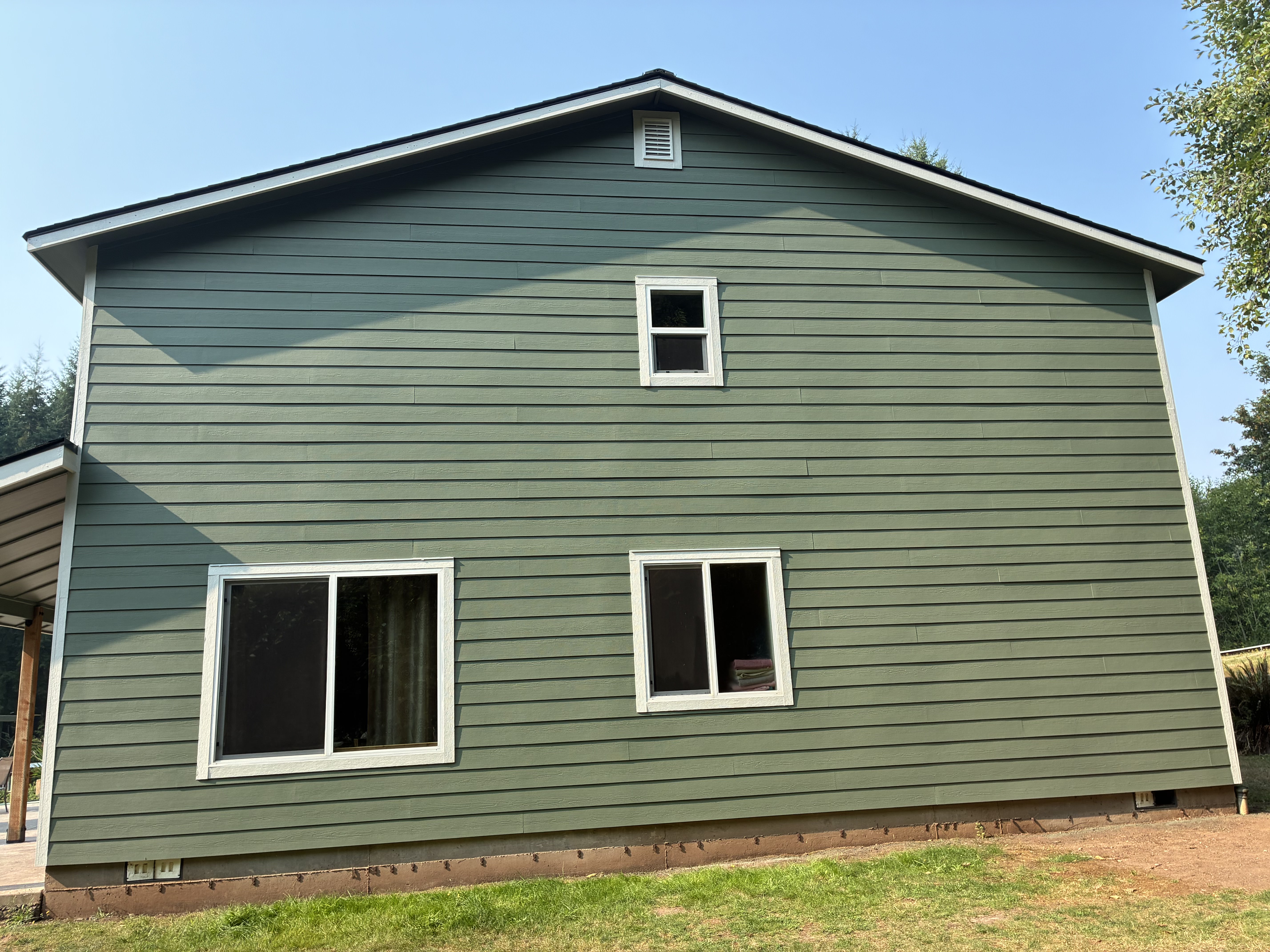 Sage green lap siding and white trim on a finished two-story home