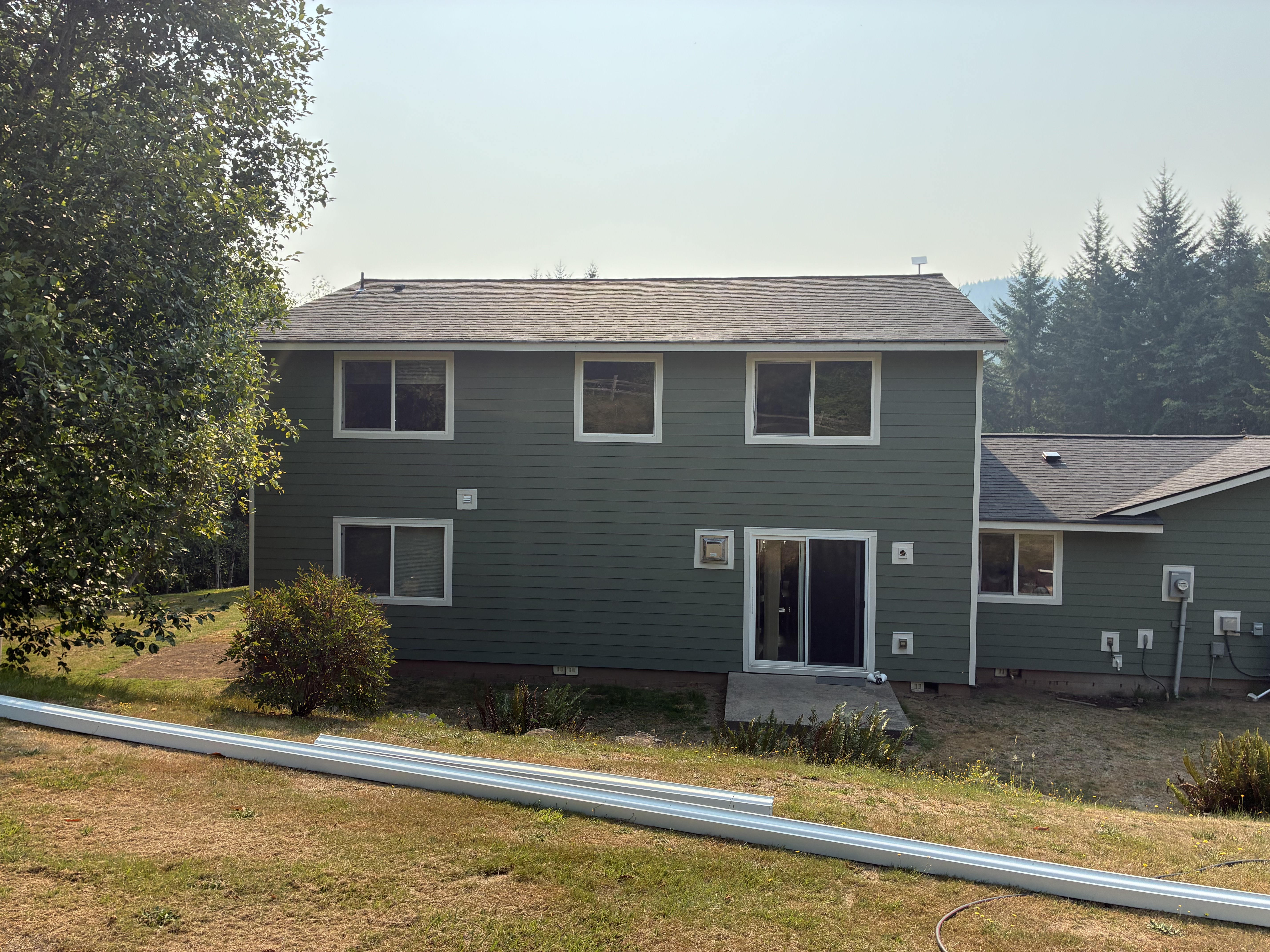 Rear elevation with sage green siding and white trim after the exterior refresh